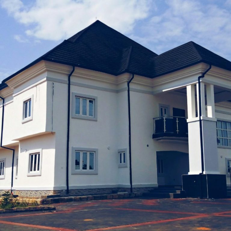 Moderne, zweistöckige, weiße Gebäude mit mehreren Fenstern und einem Balkon.